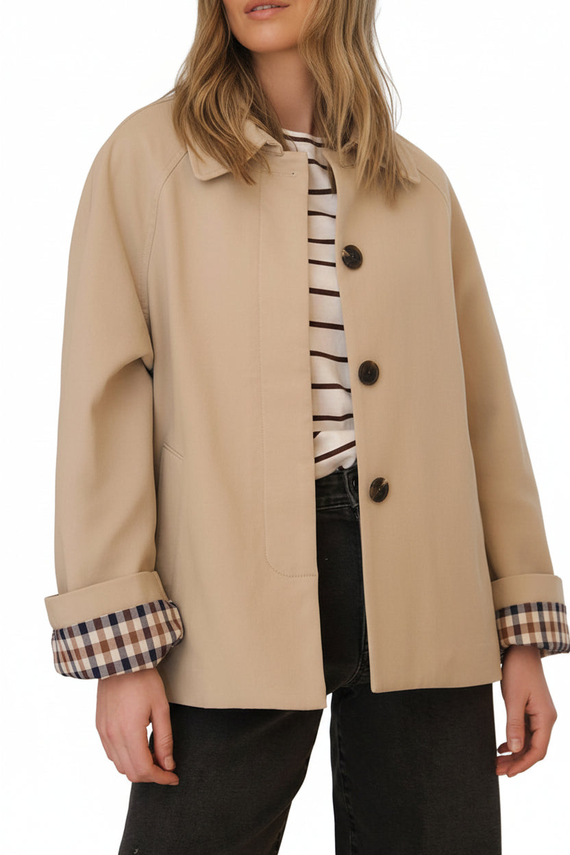 Neutral parchement and plaid short trench coat for your on-the-go customer. Classic plaid lining and folding sleeves, pockets and buttons with hidden placket creates a timeless and versatile look on any body type.