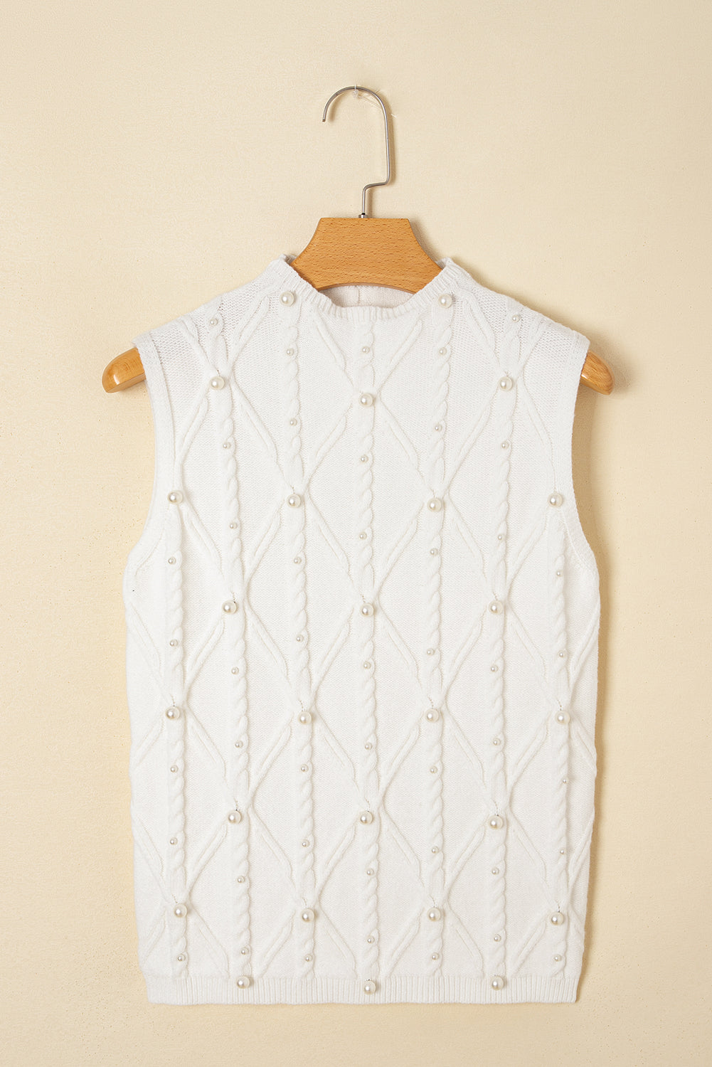 White quilted vest with beaded details on a beige background